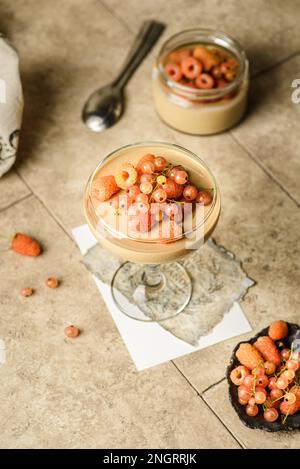 panna Cotta mit Himbeeren und Johannisbeeren. Kaffeepannencotta mit gelben Himbeeren und Johannisbeeren Stockfoto