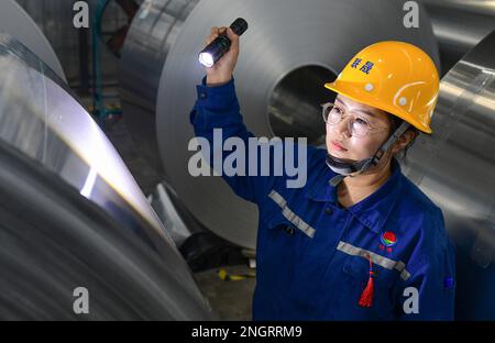 HOLINGOL, CHINA - 19. FEBRUAR 2023 - Ein Qualitätsinspektor arbeitet an einer Produktionslinie für hochwertige Aluminiumfolien in einer Werkstatt der inneren Mongolei Liansh Stockfoto