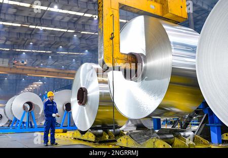 HOLINGOL, CHINA - 19. FEBRUAR 2023 - Ein Arbeiter arbeitet an einer Produktionslinie für hochwertige Aluminiumfolien in einer Werkstatt der Inner Mongolia Liansheng New Ene Stockfoto