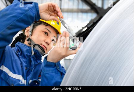 HOLINGOL, CHINA - 19. FEBRUAR 2023 - Ein Arbeiter arbeitet an einer Produktionslinie für hochwertige Aluminiumfolien in einer Werkstatt der Inner Mongolia Liansheng New Ene Stockfoto