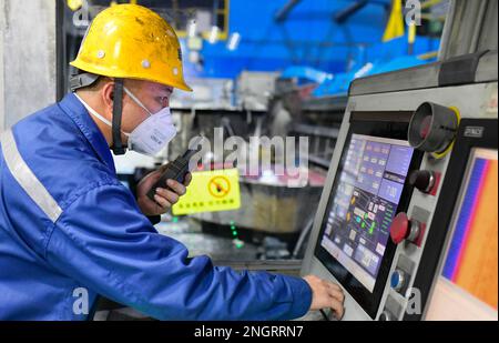 HOLINGOL, CHINA - 19. FEBRUAR 2023 - Ein Arbeiter arbeitet an einer Produktionslinie für hochwertige Aluminiumfolien in einer Werkstatt der Inner Mongolia Liansheng New Ene Stockfoto