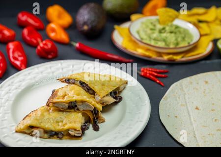 Quesadilla mit Hühnerfleisch und Bohnen und Guacamole mit Nachos Stockfoto