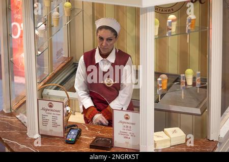 Moskau, Russland. 17. Februar 2023. Eine Frau verkauft Eiscreme in einem Kiosk an einem Eingang im KAUGUMMIGESCHÄFT im Zentrum von Moskau, Russland Stockfoto