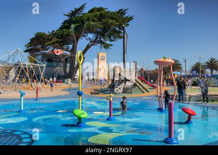 31. Dezember 2022: Christchurch, Neuseeland - New Brighton Splash Park und Spielplatz an einem warmen Sommertag spielen Kinder und Familien im Wasser Stockfoto