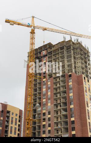 Moskau, Russland - 04. Februar 2023: Bau eines Apartmentgebäudes. Baukran auf der Baustelle. Ein Haus in der Stadt bauen. Stockfoto