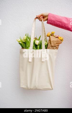 Tragetasche mit Blumen halten Stockfoto