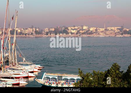 Touristenboote für die Überquerung des Nils in Luxor. Das Tal der Könige am Horizont. Luxor, Ägypten. Afrika. Stockfoto