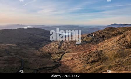 Luftbild einer Drohne mit Blick auf den Sonnenaufgang, Winterblick von Red Screes im Lake District mit Blick auf Windermere in der Ferne über Wansfell Pike Pea Stockfoto