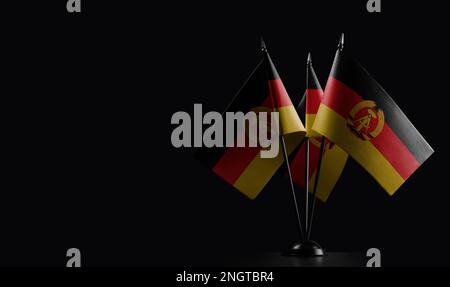 Kleine Nationalflaggen der DDR auf schwarzem Hintergrund Stockfoto