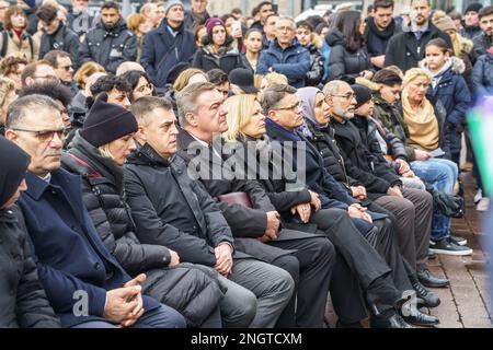 Hanau, Deutschland. 19. Februar 2023. Claus Kaminsky (SPD, 5. von links), Bürgermeister von Hanau, Nancy Faeser (SPD, M), Bundesminister des Innern, Boris Rhein (CDU, 7. von links), Ministerpräsident von Hessen, sitzt neben Verwandten der Opfer bei einer Gedenkfeier auf dem Marktplatz, um an die neun Opfer des rassistischen Angriffs in Hanau vor drei Jahren zu erinnern. Ein 43-jähriger Deutscher hatte neun Menschen aus rassistischen Motiven erschossen und dann seine Mutter und sich selbst getötet. Kredit: Frank Rumpenhorst/dpa/Alamy Live News Stockfoto