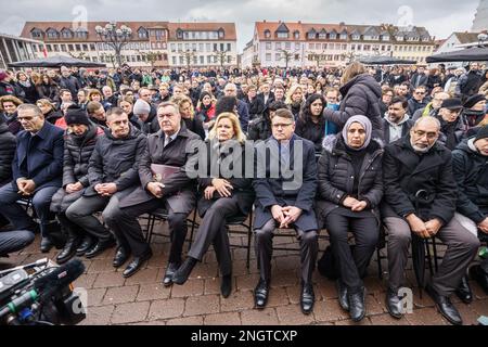 Hanau, Deutschland. 19. Februar 2023. Claus Kaminsky (SPD, 4. von links), Lord Mayor of Hanau, Nancy Faeser (SPD, 5. von links), Bundesminister des Innern, Und Boris Rhein (CDU, M), Ministerpräsident von Hessen, sitzt neben Verwandten der Opfer bei einer Gedenkfeier auf dem Marktplatz, um an die neun Opfer des rassistischen Anschlags in Hanau vor drei Jahren zu erinnern. Ein 43-jähriger Deutscher hatte neun Menschen aus rassistischen Motiven erschossen und dann seine Mutter und sich selbst getötet. Kredit: Frank Rumpenhorst/dpa/Alamy Live News Stockfoto