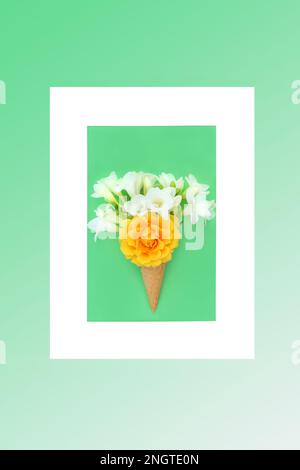 Surreale Sommerblumen Eiswaffelkonus bizarres Konzept mit Rosen- und Freesienblumen mit Rahmen. Abstrakte Minimalzusammensetzung von Naturnahrungsmitteln. Stockfoto