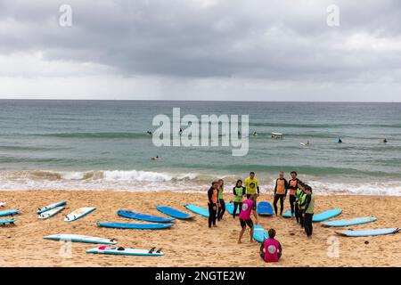 Gruppe von Personen, die im Sommer 2023 Surfunterricht am Manly Beach in Sydney, Australien, haben Stockfoto