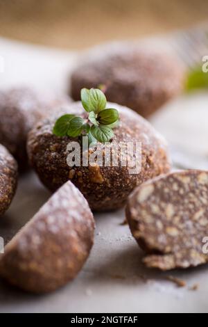 Schokoladen-Süßkuchen aus pürierten Keksen mit Zusatzstoffen auf Backpapier. Stockfoto