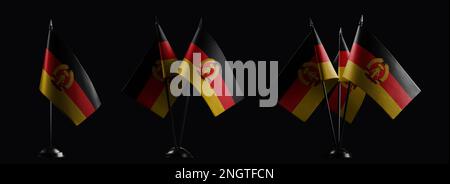 Kleine Nationalflaggen der DDR auf schwarzem Hintergrund Stockfoto
