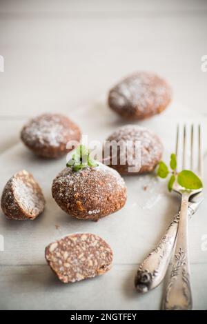 Schokoladen-Süßkuchen aus pürierten Keksen mit Zusatzstoffen auf Backpapier. Stockfoto