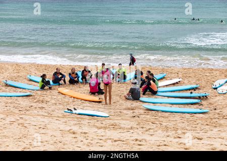 Gruppe von Personen, die im Sommer 2023 Surfunterricht am Manly Beach in Sydney, Australien, haben Stockfoto