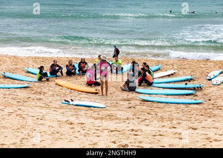 Gruppe von Personen, die im Sommer 2023 Surfunterricht am Manly Beach in Sydney, Australien, haben Stockfoto