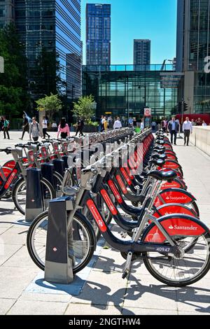 London, England, Vereinigtes Königreich - Juni 2022: Mietfahrräder werden vor Bürogebäuden in Canary Wharf geparkt. Die Motorräder werden von der Santander Bank gesponsert. Stockfoto