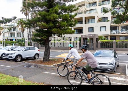 Zwei männliche Radfahrer, die Fahrradhelme tragen und auf dem gemeinsamen Pfad in Manly Beach, Sydney, NSW, Australien fahren Stockfoto