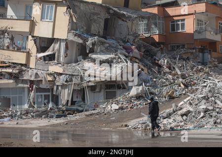 Kharamanmaras, Türkei. 18. Februar 2023. Ein Mann geht an einem eingestürzten Haus vorbei, im Epizentrum des Erdbebens. Ein Erdbeben der Stärke 7,7 mit Epizentrum in der südöstlichen türkischen Provinz Kharamanmaras ereignete sich in den frühen Morgenstunden des 6. Februar. Die Menschen in Erdbebengebieten müssen auch in den nächsten Tagen mit starken Beben rechnen. Kredit: Ahmed Deeb/dpa/Alamy Live News Stockfoto