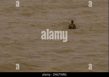 Margate, Großbritannien. 18. Februar 2023 Besucher besuchen Antony Gormley: Ein anderes Mal, am Nayland Rock, neben dem Turner Contemporary, in Margate. Das Werk wird erst enthüllt, wenn die Flut zurückgeht. Es ist eine von hundert soliden gusseisernen Figuren von Antony Gormley, die die Erfahrung des menschlichen Wesens erforschen. Leben an der Margate Küste. Kredit: Guy Bell/Alamy Live News Stockfoto