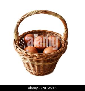 Ostereier im Korb isoliert auf weißem Hintergrund. Osterei gefärbt mit Zwiebelschale. Frohes Osterkonzept. Stockfoto