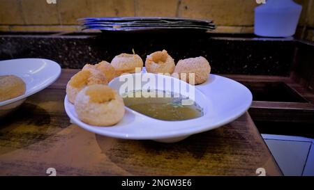 Pani Puri oder Golgappa oder Puchkas von einem weißen Teller, das ein beliebtes indisches Chat-Menü ist. Stockfoto