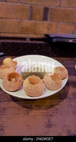 Pani Puri oder Golgappa oder Puchkas von einem weißen Teller, das ein beliebtes indisches Chat-Menü ist. Stockfoto