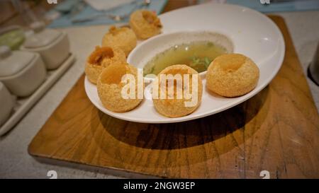 Pani Puri oder Golgappa oder Puchkas von einem weißen Teller, das ein beliebtes indisches Chat-Menü ist. Stockfoto