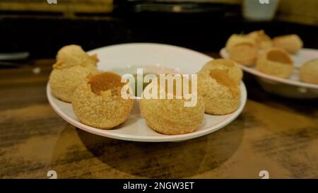 Pani Puri oder Golgappa oder Puchkas von einem weißen Teller, das ein beliebtes indisches Chat-Menü ist. Stockfoto