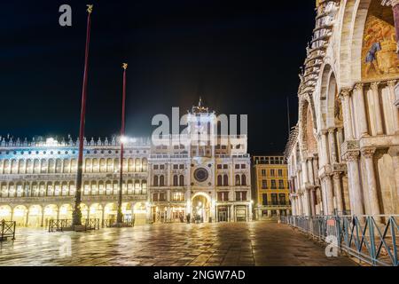 Venedig Italien Nachtsicht auf den Uhrenturm des Markusdoms auf dem gleichnamigen Platz, mit seitlichem Blick auf den Eingang des Markusdoms. Stockfoto