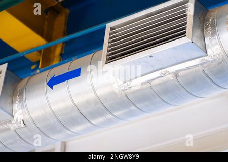 Entlüftungsleitung mit Lufteinlassgitter. Industriehaube in der Werkstatt. Stockfoto