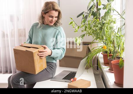 Nahaufnahme eines weiblichen Online-Shops, Inhaber eines kleinen Unternehmens, Unternehmer, der Verpackungspakete nach dem Versand vorbereiteter Versandkarton auf dem Tisch vorbereitet Stockfoto