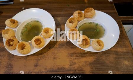 Zwei Teller Pani Puri, Golgappa oder Puchkas von einem weißen Teller, das ein beliebtes indisches Chat-Menü ist. Stockfoto