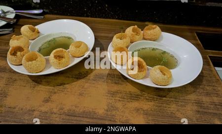 Zwei Teller Pani Puri, Golgappa oder Puchkas von einem weißen Teller, das ein beliebtes indisches Chat-Menü ist. Stockfoto