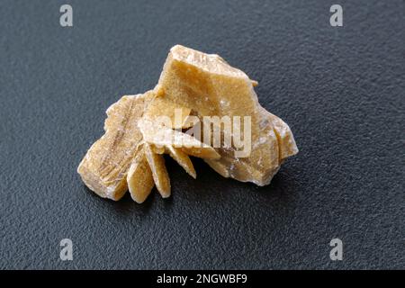 Wüstenrose. Natürliche Mineralnahaufnahme eines Steinansatzes aus Sandgipskristall, schwarzer Hintergrund Stockfoto