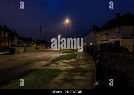 Straße von Mittelschicht-/Arbeiterhäusern mit Autos, die nachts auf der Straße im Vorort Cardiff geparkt werden Stockfoto