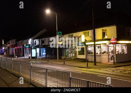 Chinesisches Essen am Abend in einer Vorstadtstraße mit Kunden, die drinnen warten. Leere Straße. Stockfoto