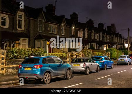 Straße mit Terrassenhäusern der Mittelklasse, wobei nachts Autos auf der Straße in einem Vorort von Cardiff geparkt werden Stockfoto