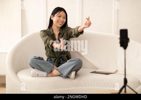 Süße chinesische Vloggerinnen-Gesten, die Inhalte für Follower aufzeichnen Stockfoto