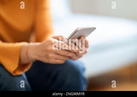 Nahaufnahme Einer Nicht Wiedererkennbaren Frau, Die Zu Hause Ein Mobiltelefon Benutzt Stockfoto