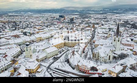 Blick aus der Vogelperspektive auf das historische Stadtzentrum von Sibiu, Rumänien, bei Sonnenuntergang. Drohnenfotografie der Stadtlandschaft von oben mit dem kleinen Quadrat und dem t Stockfoto