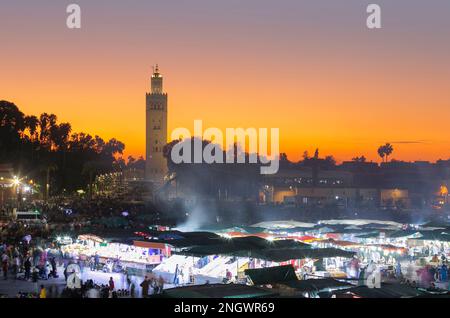 jemaa el Fna bei Sonnenuntergang. Die Nacht naht und das Stadtleben beginnt auf dem Markt. Stockfoto