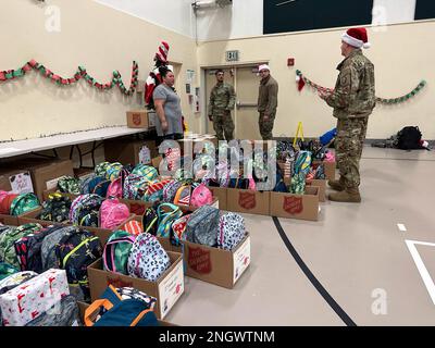 Freiwillige bei der Nationalgarde Alaska, der Heilsarmee und lokalen Partnern helfen an der Trapper School in Nuiqsut am 29. November 2022 beim Sortieren von Geschenken für die Operation Santa Claus. Die Operation Santa Claus ist das alljährliche Programm der Alaska National Guard für die Zusammenarbeit und Unterstützung der Gemeinschaft, das Kindern in entlegenen Gemeinden im ganzen Bundesstaat Geschenke überreicht. In Zusammenarbeit mit der Heilsarmee lieferten der Weihnachtsmann, Frau Claus und mehr als drei Dutzend Elfen 1.420 Pfund Geschenke, Rucksäcke, Hygieneartikel und Bücher an 191 Kinder in Nuiqsut. (Alaska National Guard Foto von 1. LT. Balinda O’Neal) Stockfoto