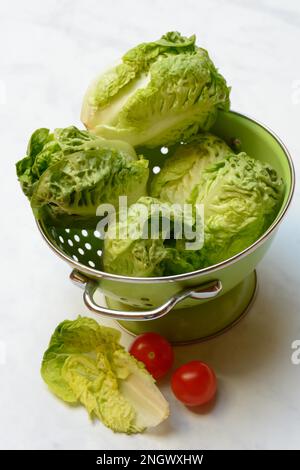 Babysalat in Küchensieb und Tomaten Stockfoto