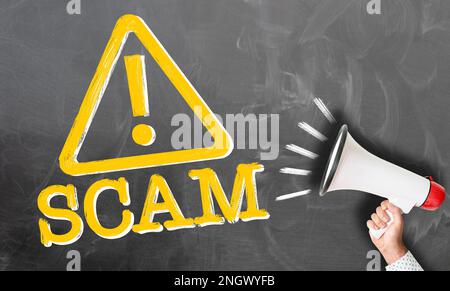 Hand Megaphon gegen Tafel mit Wort scam und Warnschilder Stockfoto