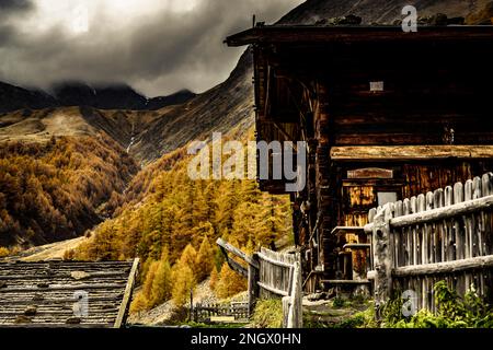 Alpenhütte in herbstlicher Berglandschaft mit bedrohlichem bewölktem Himmel, Pfossental, Merano, Vinschgau, Südtirol, Italien Stockfoto