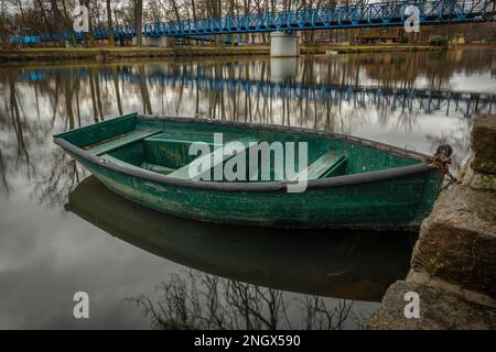 Kleines grünes Holzboot auf dem Fluss Otava in Pisek am Wintermorgen Stockfoto