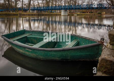 Kleines grünes Holzboot auf dem Fluss Otava in Pisek am Wintermorgen Stockfoto